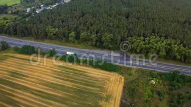 白色卡车在茂密的森林中行驶在高速公路上。 在森林沥青路上行驶的空中镜头。 公路